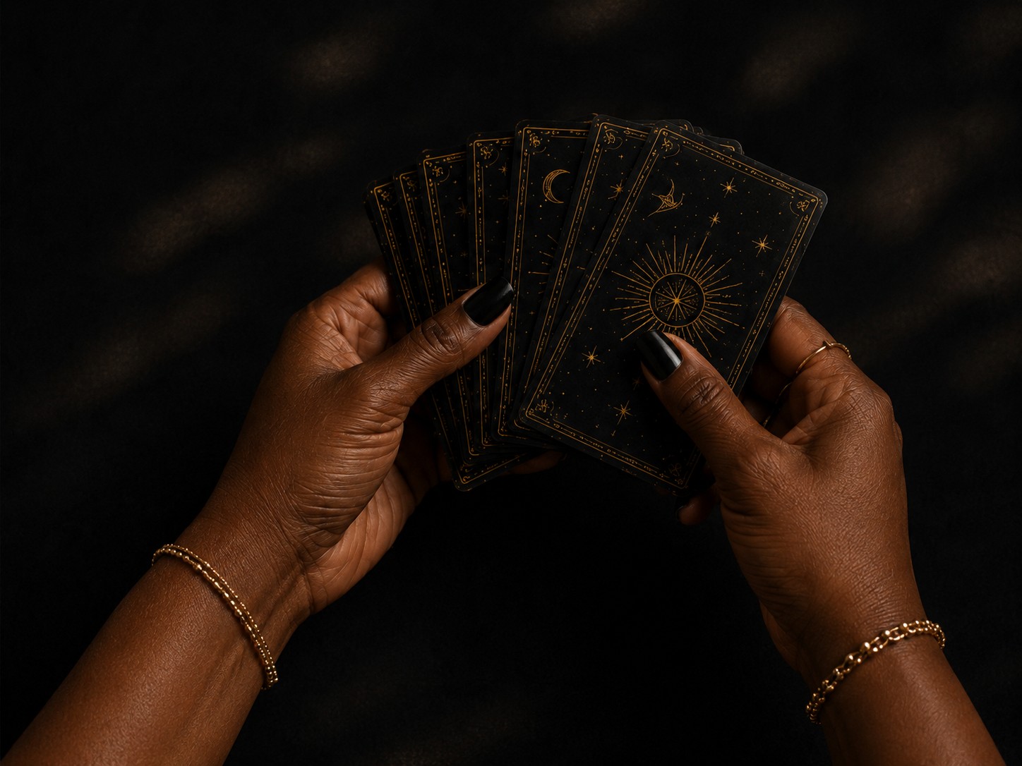 Black hands holding tarot cards during an event reading