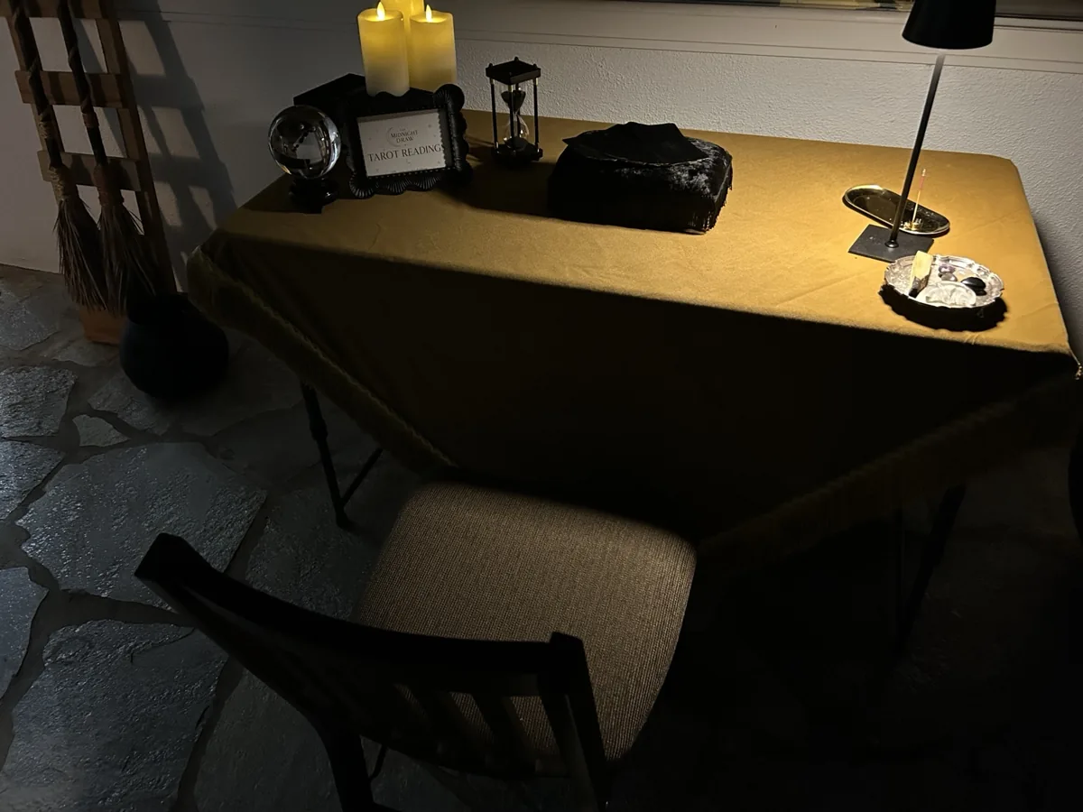 Golden Enchantment reading table with gold covering, candles, tarot cards and guest seating
